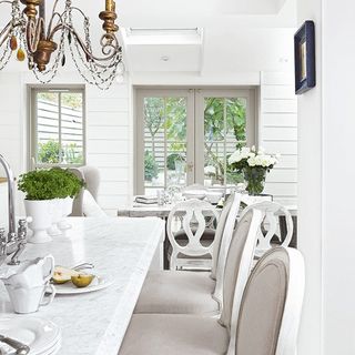 white dining room with table and flower vase