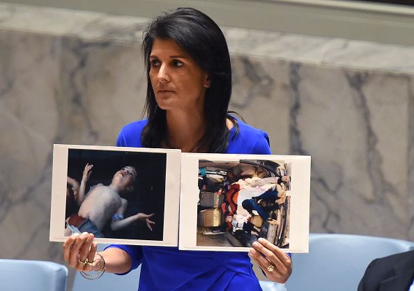 Nikki Haley holds up photos of victims of the Syria chemical attack.