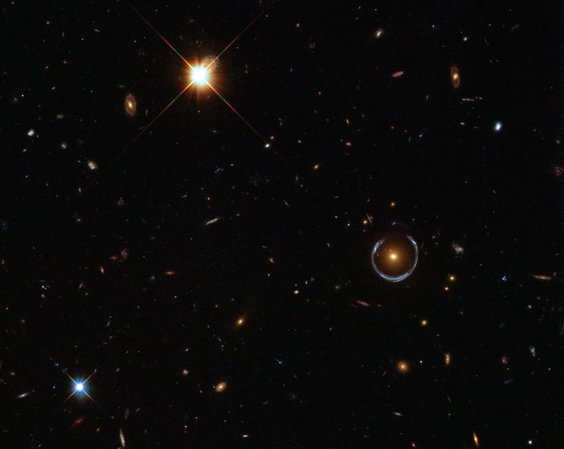 This image shows an Einstein ring (middle right), which occurs when a massive object acts like a lens for light coming toward the observer from a background object.