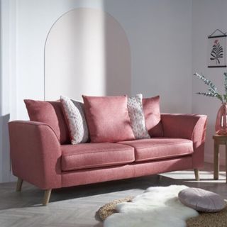 A pink sofa scattered with pink and grey cushions