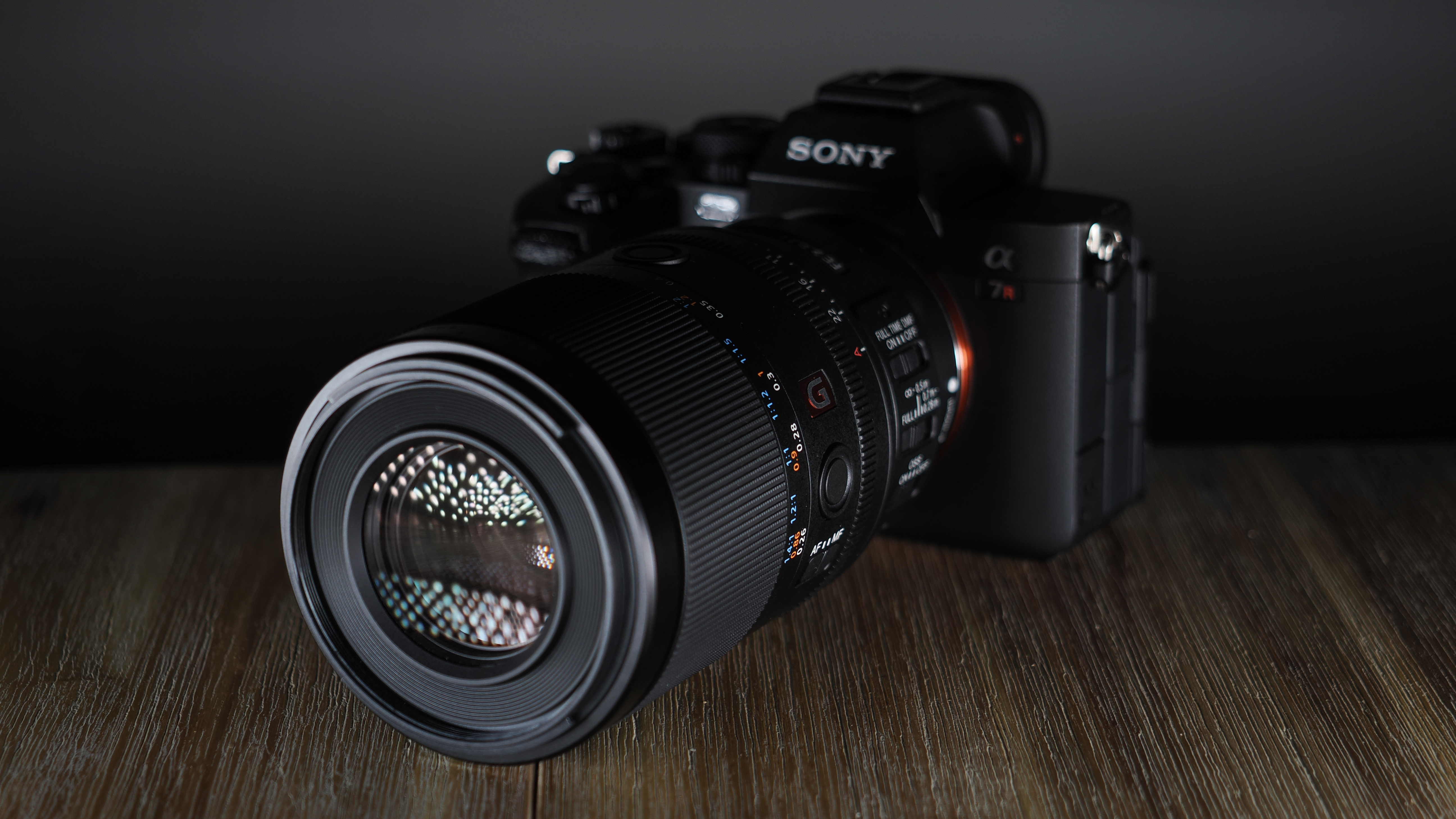 Sony FE 100mm f/2.8 Macro GM OSS on a wooden surface