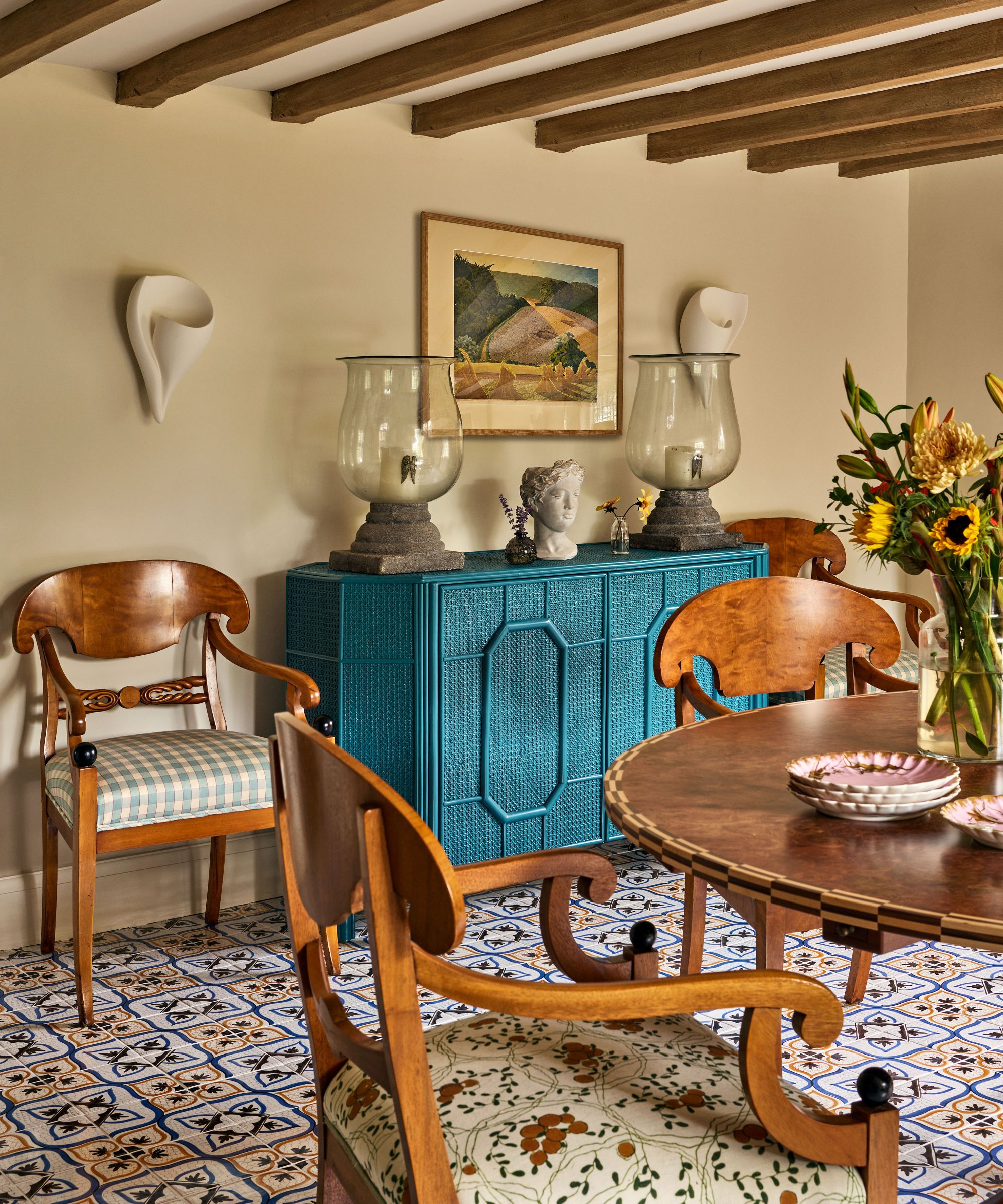 Cream dining room with wooden beams, vintage furniture and a blue console table