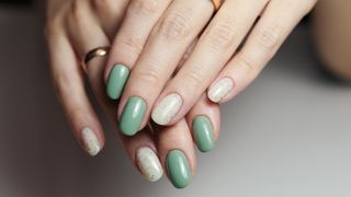 hands with greena dn cream nail polish