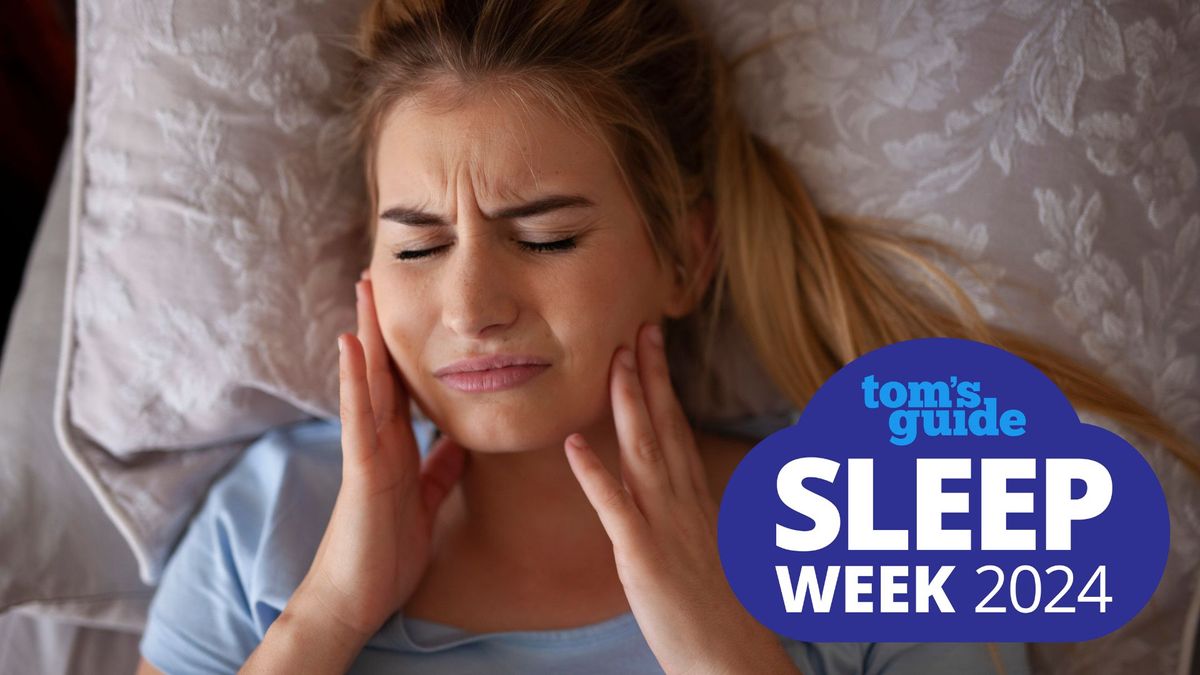 A woman holds her jaw in pain after grinding her teeth