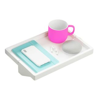 A white rectangular bed shelf with a pink mug and a phone on top of it