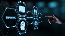 A hand pointing towards a screen displaying Training, Development, Skills concepts