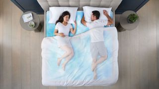 A couple laying in Sleep Number ClimateCool smart bed