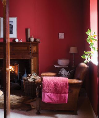 living room with walls painted in deep red and dark brown leather sofa