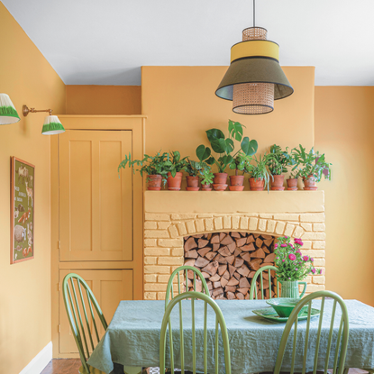 Warm yellow dining room with lots of house plants and white ceiling.