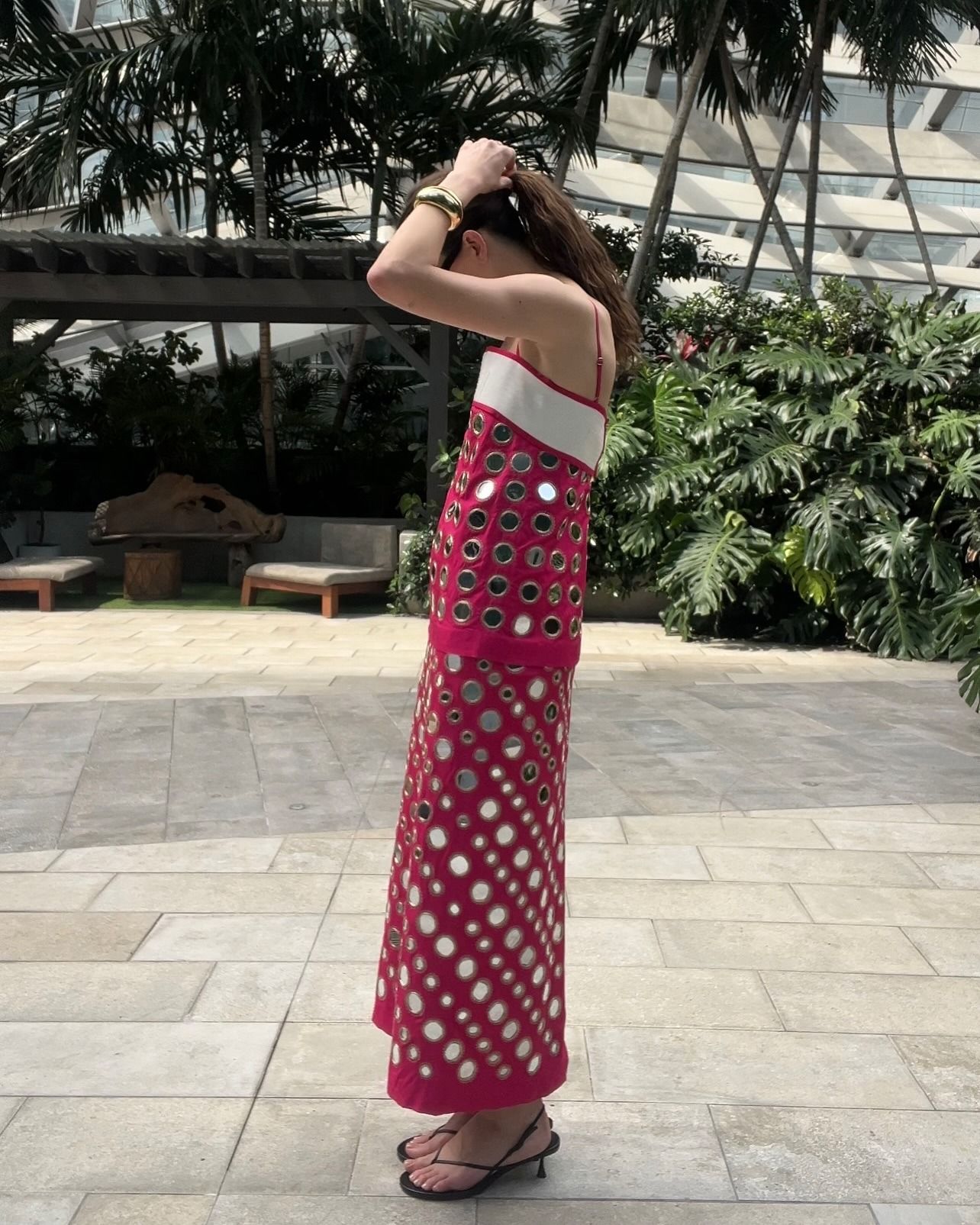 Eliza Huber in Miami wearing a pink mirrored dress by Tory Burch.