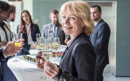 Senior business woman at a party with her business colleagues