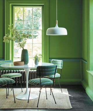 best green paints, bright green dining room with white accents, checked dining chairs, white table and pendant, colour drenched