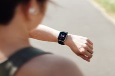 A woman looking at her smart watch on a run