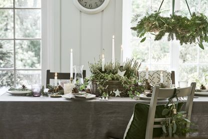 Christmas table centerpiece ideas with moss and white candles by Neptune
