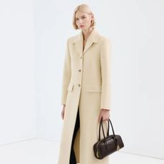 Model wears H&M v-neck white jumper.