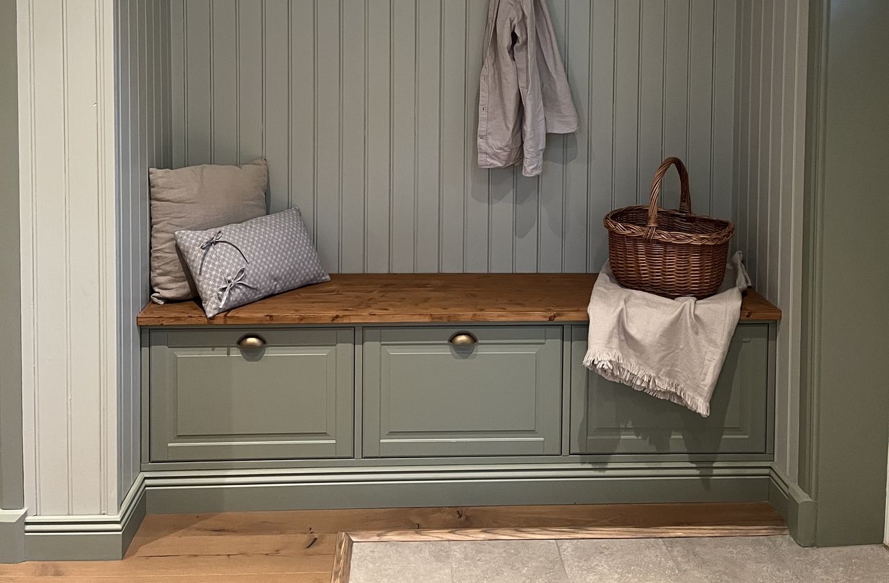 A small seating area in a panelled alcove that doubles up as storage