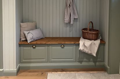 A small seating area in a panelled alcove that doubles up as storage