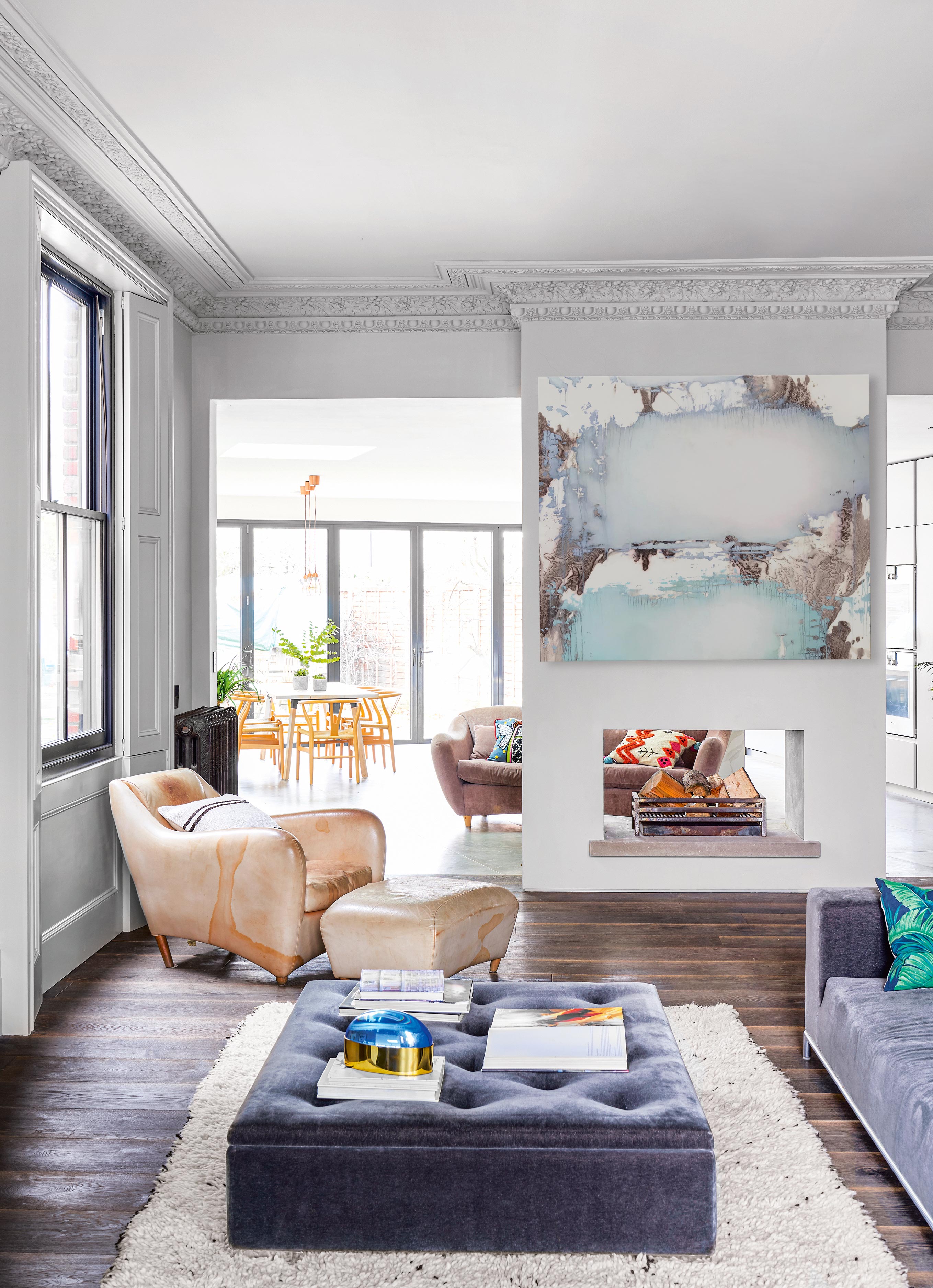 Open plan living room apartment with fireplace and velvet ottoman