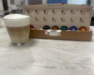 A prepared latte macchiato with selection of Nespresso Lattissma compatible coffee capsule