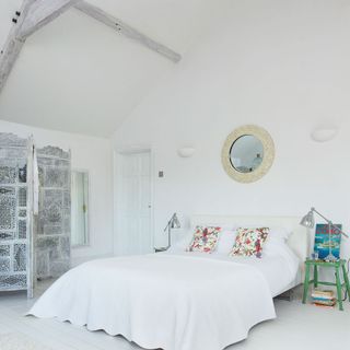 white bedroom with high ceiling with white washed beams