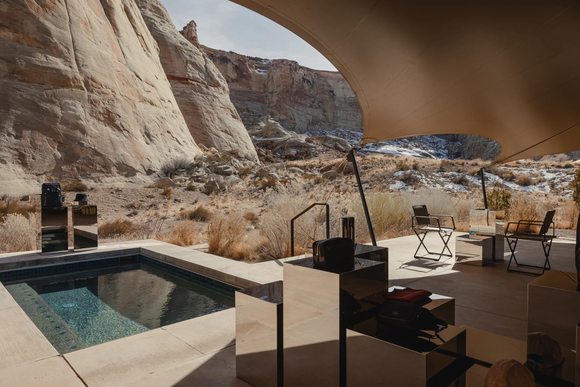 The offering of a sleek hotel gift shop is set up among the dramatic mountain range of Utah's desert, nestled either within a camel tent decorated with sophisticated, reflective furniture, or en-plain-air in dialogue with the outdoors.