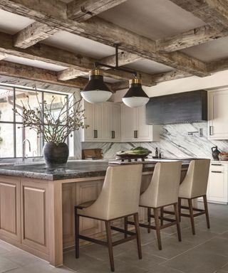 kitchen with wooden beams island black wortkops and beige bar stools with backs
