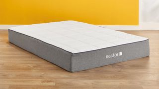 Nectar Memory Foam Mattress on a wooden floor with a yellow wall behind