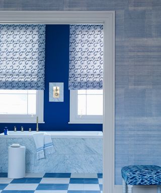 An example of bathroom pictures showing a blue and white bathroom with checkered flooring, dark blue walls and an upholstered stool