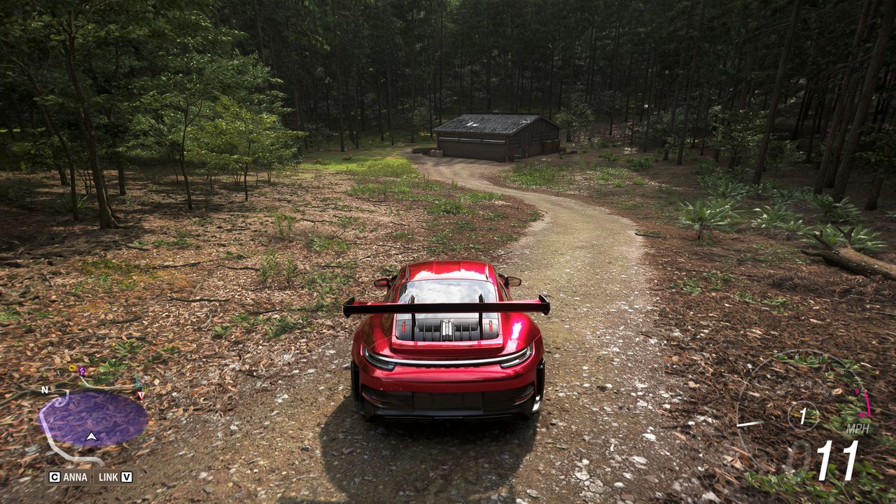 Forza Horizon 6 Barn Finds: A player parked on a dirt path ahead of an old barn in a forest.