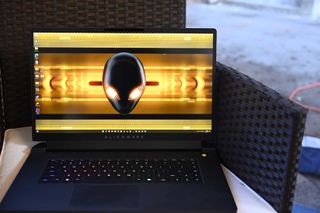 Alienware m17 R5 gaming laptop on a black wicker chair