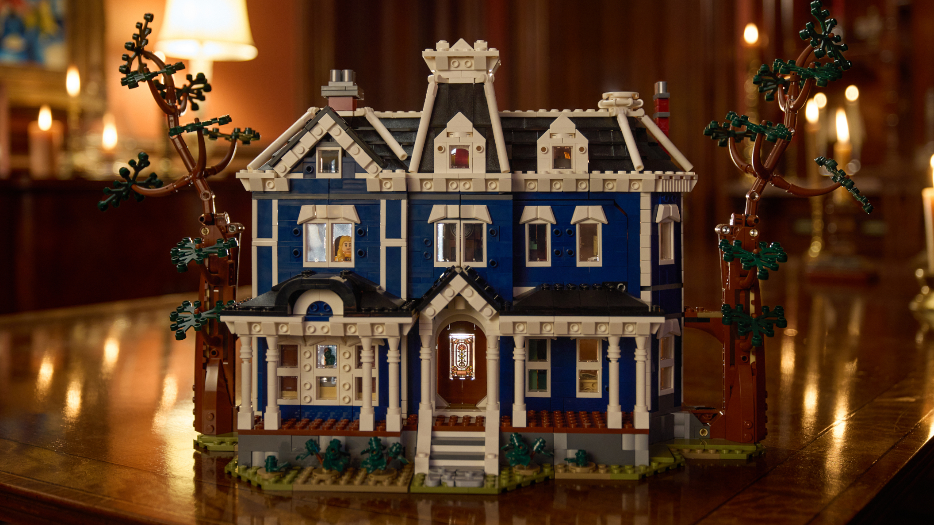 Lego The Creel House set up on a wooden table, with candles and lamps visible in the background