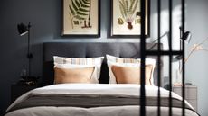 IKEA blue bedroom with grey double bed with white bedding and botanical prints above in black frames