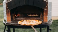 Taking a pizza from a pizza oven
