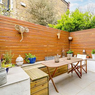 seating area with wooden fencing table and potted plants