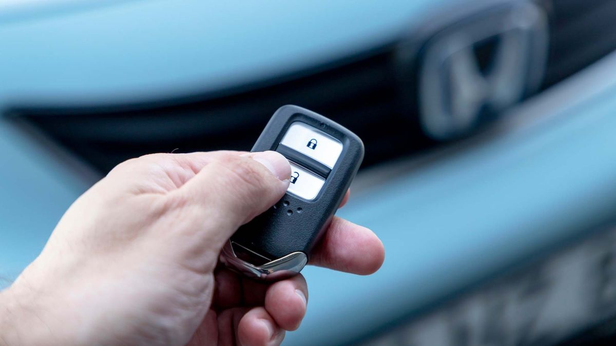 A person unlocking a Honda car using a key fob