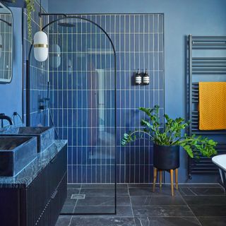 Blue tiles in a blue bathroom with a shower screen