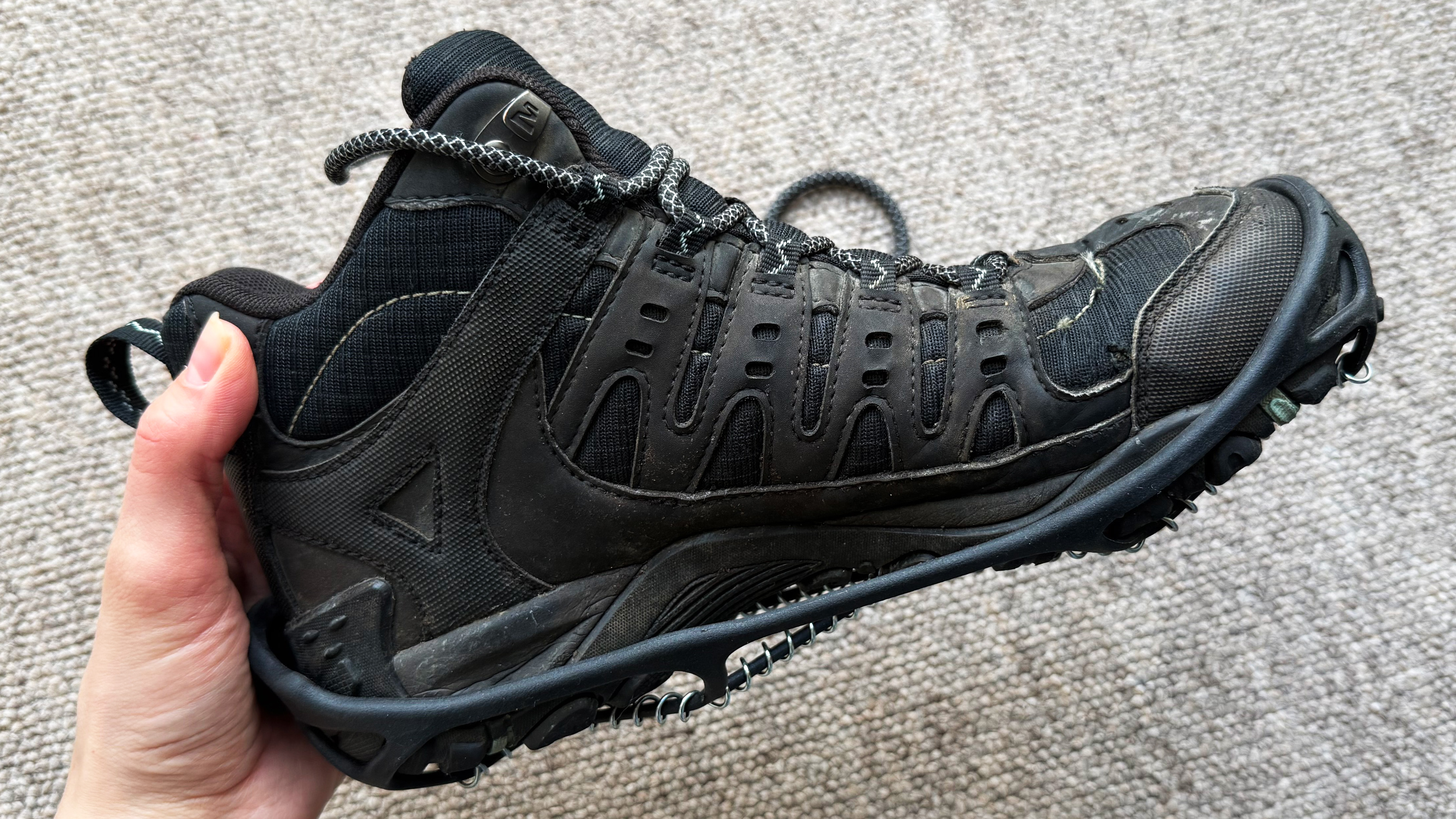 the merrell sport 3 hiking boots with yaktrax photographed inside, the sole, side, and top