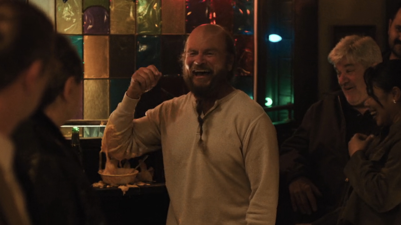 Weird man in bar dipping his elbow in soup in The Chair Company Episode 5