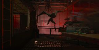 A long-limbed alien creature attacks in a warehouse