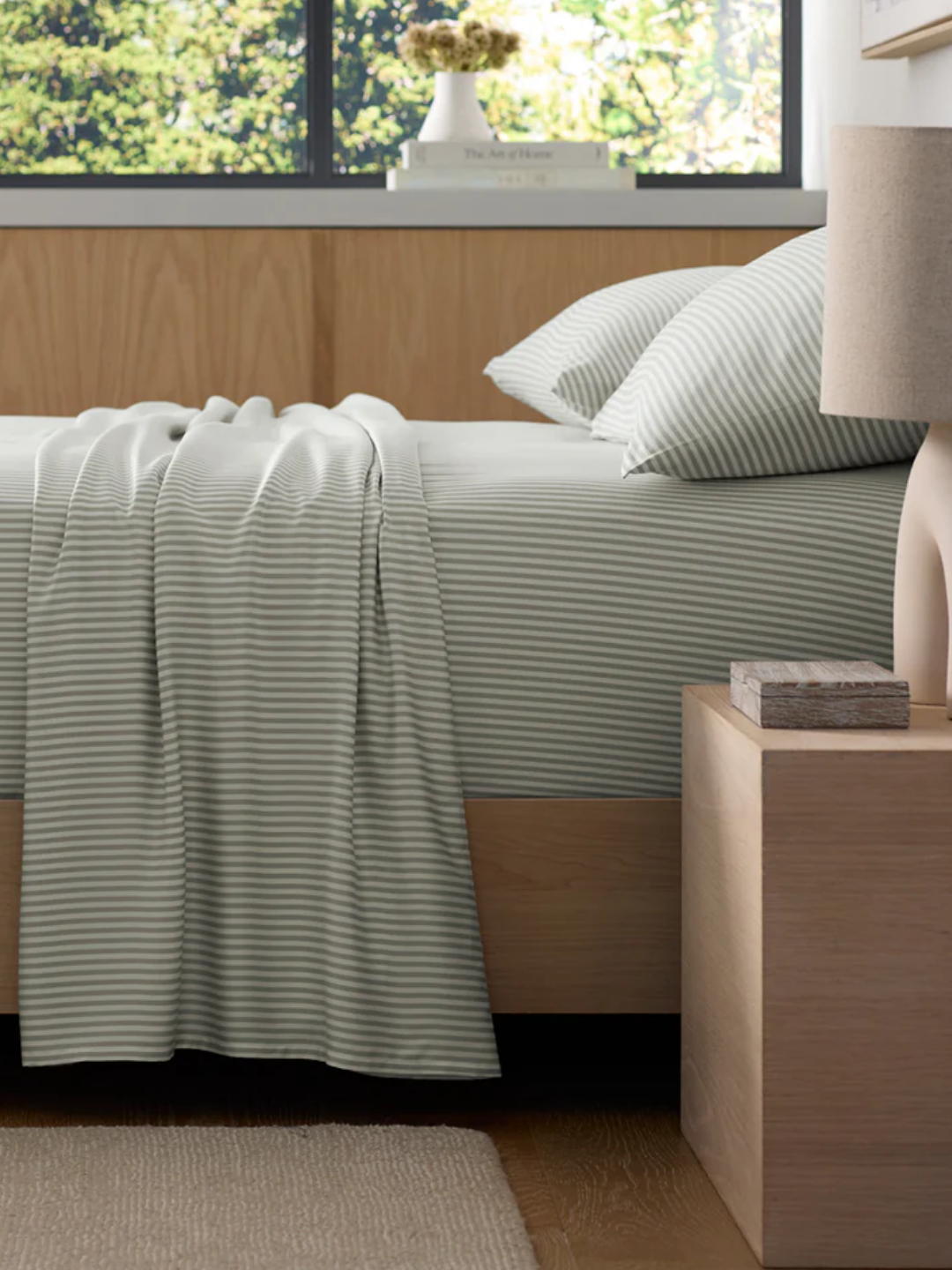 A bedroom with a striped blue and white bedscape
