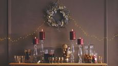 Drinks table with red pillar candles and gold wine glasses