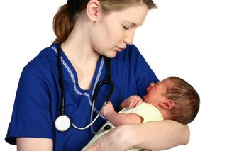 A nurse cradles a baby.