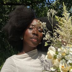 A selfie of @daniellejinadu holding a bouquet of white flowers