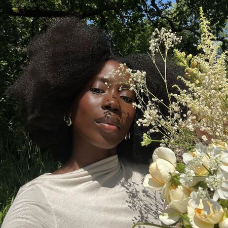 A selfie of @daniellejinadu holding a bouquet of white flowers