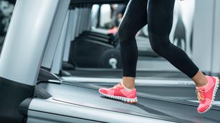 A woman feeling the incline walking benefits on a treadmill in the gym