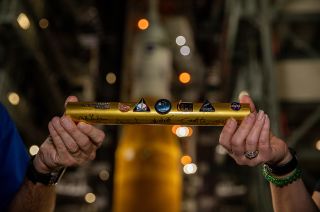 A symbolic baton is handed off inside the Vehicle Assembly building at NASA's Kennedy Space Center in Florida on Aug. 15, 2022, ahead of the rollout of the Artemis I Space Launch System rocket and Orion spacecraft to Launch Complex 39B.