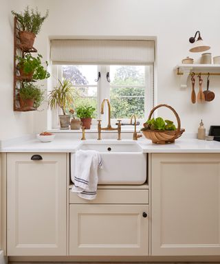 belfast sink under window in a neutral cottage kitchen