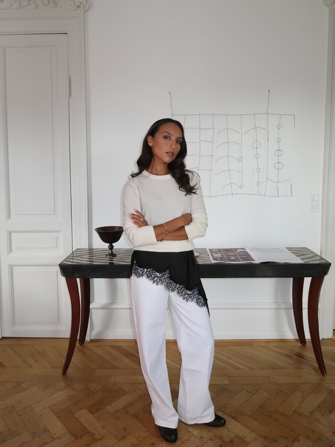 Woman in white sweater, lace-trim dress and white jeans