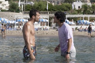 Theo James and Will Sharpe in 'The White Lotus' season 2 arguing with each other in the water by the beach