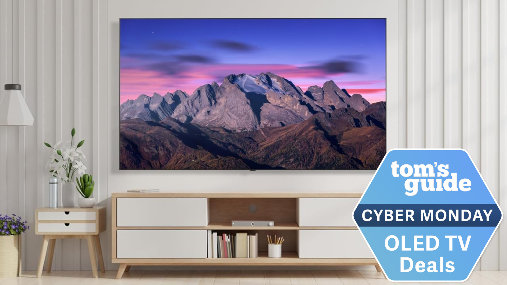 The LG B5 OLED mounted on a living room wall displaying a mountain range at sunset